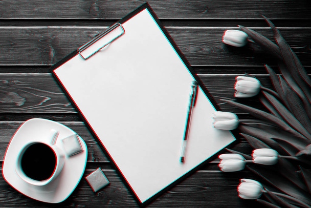 Witte tulpen op een houten tafel met een kopje koffie en een lege papieren tablet - Foto, afbeelding