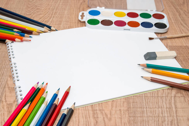 conjunto de pinturas de colores, lápices de colores y pinceles con álbum en blanco
 - Foto, Imagen