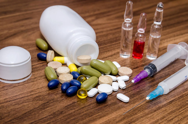 Tabletten, Injektionen und Fläschchen auf dem Tisch - Foto, Bild