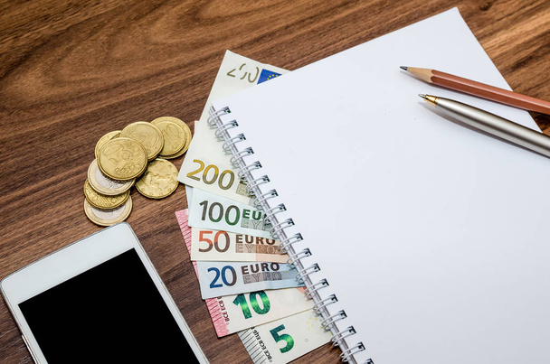 koncepcja finansowania - długopis, banknoty i kalkulator euro, przenośny i pusty notatnik - Zdjęcie, obraz