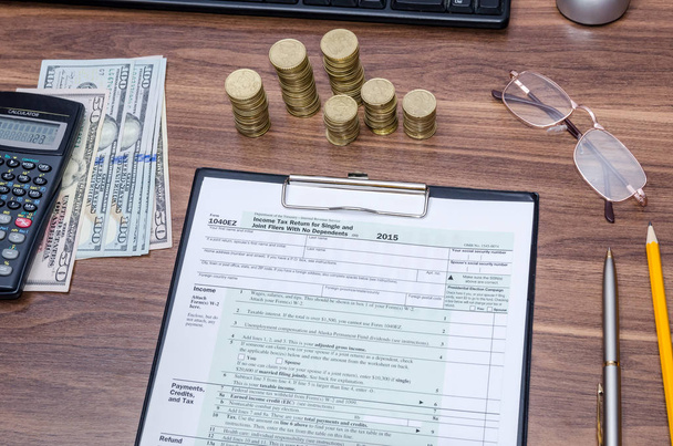 US Federal Income 1040 formulário de declaração de imposto com dinheiro e caneta
 - Foto, Imagem