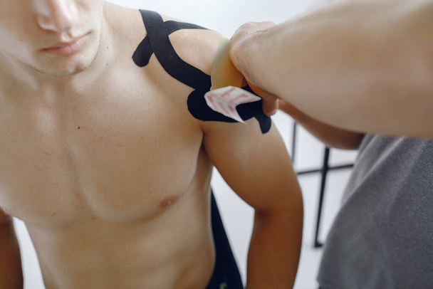 Doctor glues a tepee to an athlete at the hospital - Valokuva, kuva