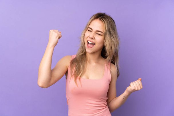Teenager Russian girl isolated on purple background celebrating a victory - Photo, Image