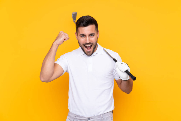 勝利を祝う孤立した黄色の背景の上にゴルファープレーヤーの男 - 写真・画像