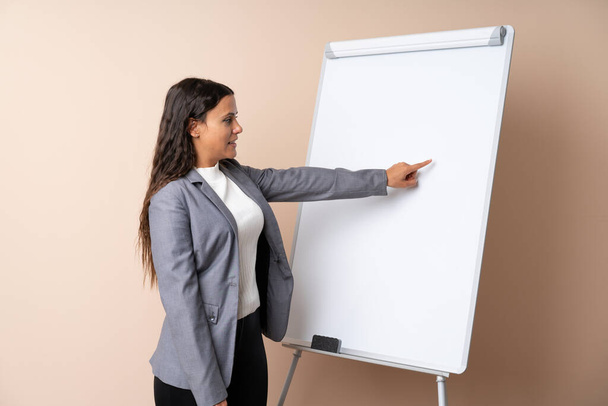 Jonge vrouw geeft een presentatie op wit bord geeft een presentatie op wit bord - Foto, afbeelding