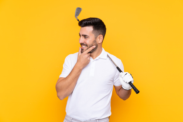 Golfer player man over isolated yellow background looking side - Fotoğraf, Görsel