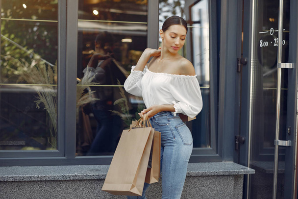 Elegant and stylish girls in a summer city with shopping bags - Foto, Imagem