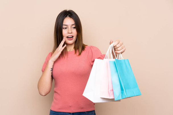 Young woman with shopping bag over isolated background with surprise and shocked facial expression - Fotoğraf, Görsel