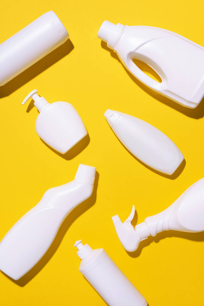 Pattern of white plastic bottles, containers of chemical cleaning products on yellow background. Top view. Flat lay. Stop plastic, recycling, separate collection of garbage concept - Foto, imagen