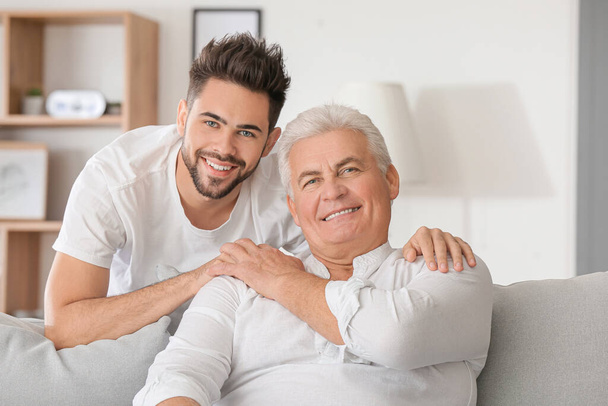 Young man and his father at home - Photo, image