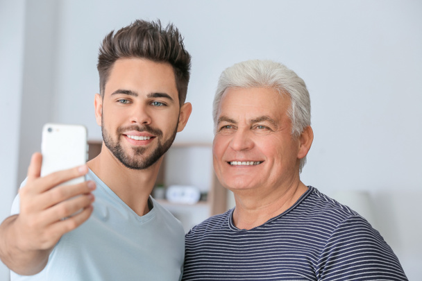 Young man and his father taking selfie at home - Photo, Image