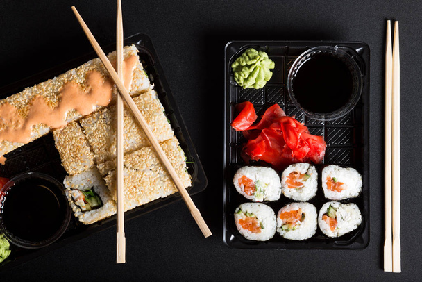 Différents types de sushis dans des boîtes. Ensembles de sushi pour aller sur fond noir. - Photo, image