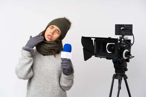 Reporter woman holding a microphone and reporting news over isolated white background with tired and sick expression - 写真・画像