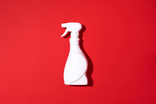 White plastic bottle of cleaning product, household chemicals or liquid laundry detergent on red background. Top view. Flat lay. Copy space. Detergent bottle - Foto, Bild