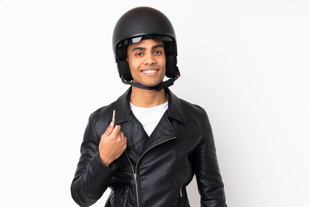 Mladý pohledný muž s motocyklovou přilbou přes izolované bílé pozadí - Fotografie, Obrázek
