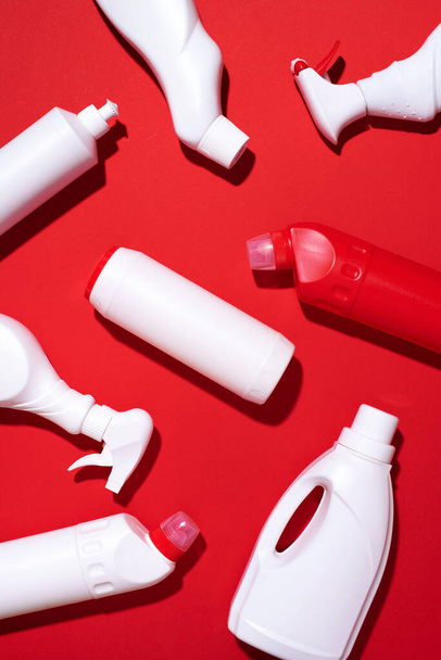 Pattern of white plastic bottles, containers of chemical cleaning products on red background. Top view. Flat lay. Stop plastic, recycling, separate collection of garbage concept - Valokuva, kuva