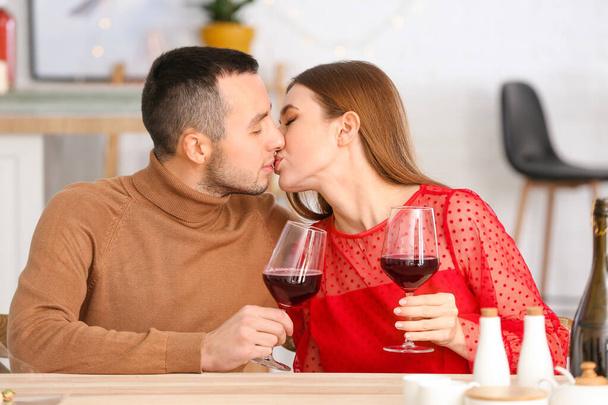Feliz joven pareja bebiendo vino en una cita romántica en la cafetería
 - Foto, imagen