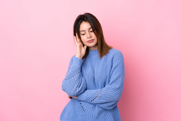Young woman with blue sweater over isolated pink background unhappy and frustrated - Foto, immagini