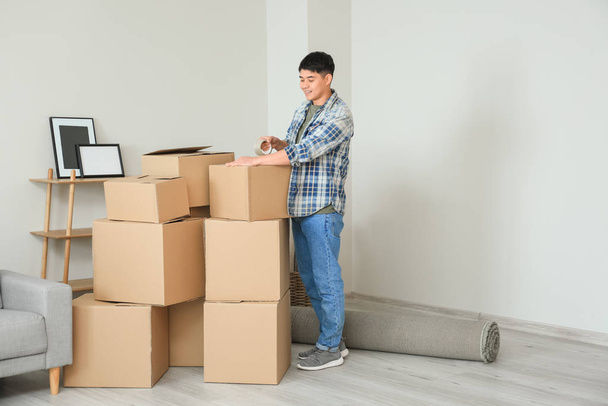 Asian man packing things on moving day - Foto, Bild