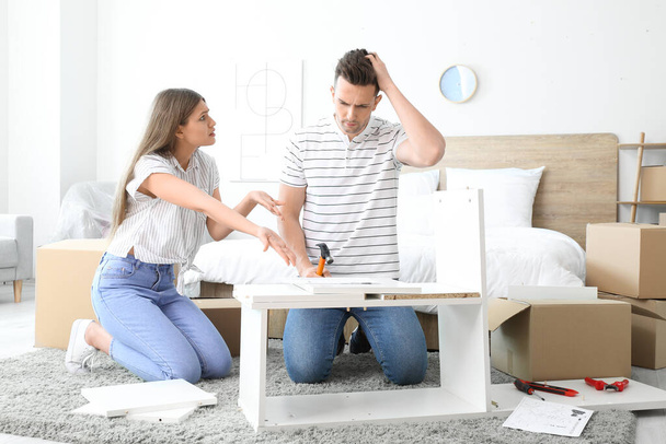 自宅で家具を組み立てる際の感情的なカップル - 写真・画像