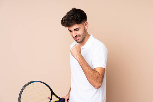 Young man over isolated background playing tennis and celebrating a victory - Foto, immagini