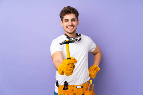 Young electrician man over isolated on purple background - Photo, Image