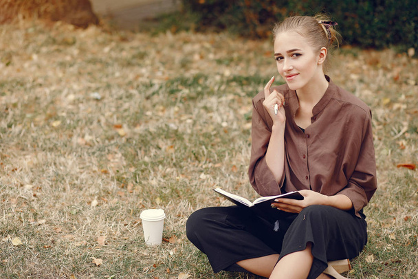 Cute student working in a park and use the notebook - Foto, Imagen