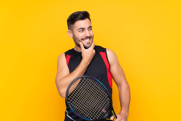 Giocatore di tennis uomo oltre isolato muro giallo cercando lato
 - Foto, immagini