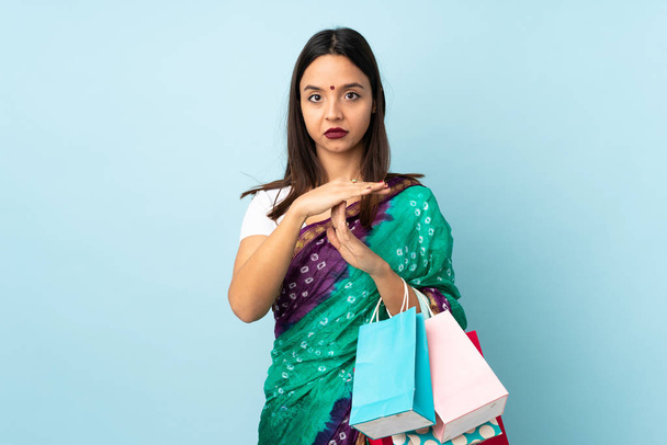 Jovem mulher indiana com sacos de compras fazendo tempo fora gesto
 - Foto, Imagem