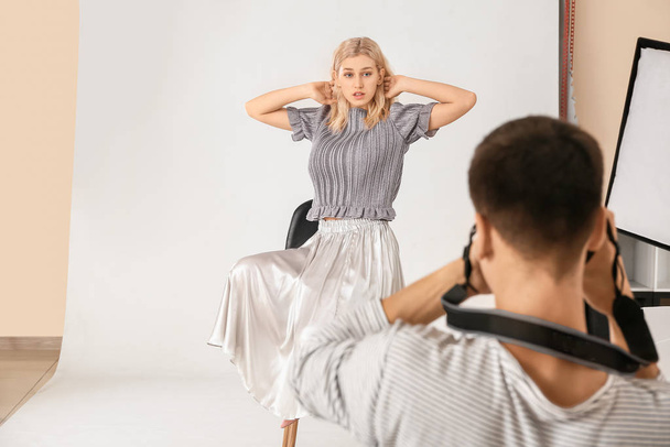 Professional photographer working with model in studio - Fotó, kép