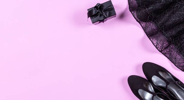 Набор модной стильной одежды и аксессуаров - черное коктейльное платье, обувь на розовом фоне, баннер. Концепция костюма для вечеринок, дня рождения, гламурной леди. Плоский, вид сверху
 - Фото, изображение