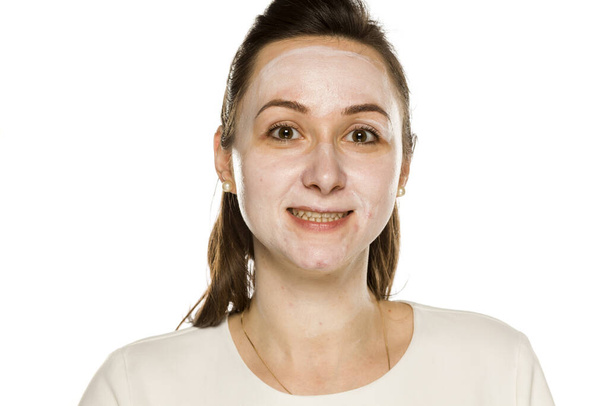 mulher feliz posando com creme de rosto no fundo branco
 - Foto, Imagem