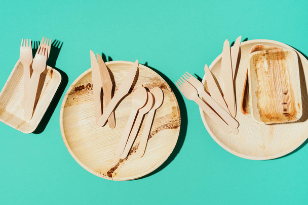 Eco craft paper tableware. Paper cups, bamboo wood dishes and wooden cutlery on blue background. Recycling or zero waste concept. Top view. Copy space - Valokuva, kuva