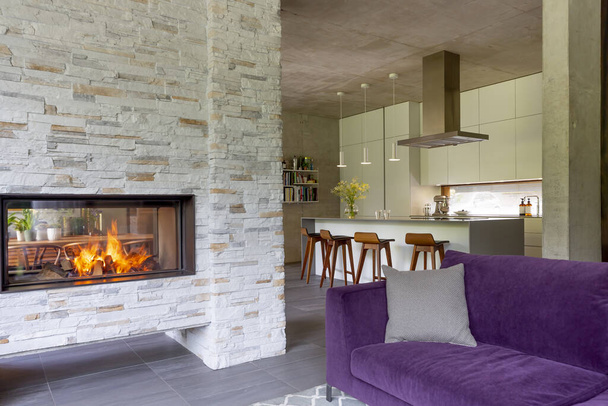 Moderne woonkamer met stenen open haard voor keuken - Foto, afbeelding