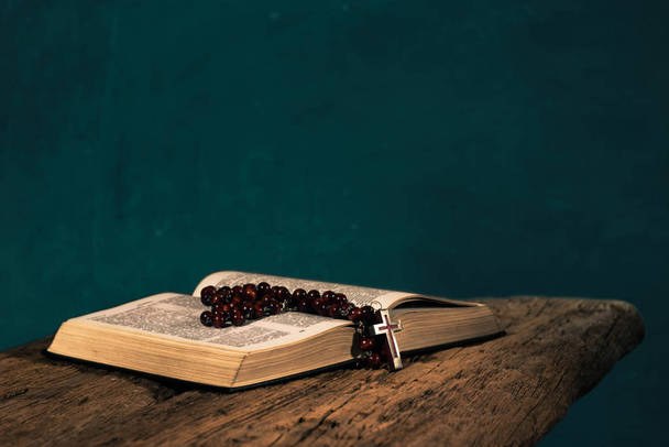 赤い古い木製のテーブルの上に聖書を開きます。美しい緑の壁の背景. - 写真・画像