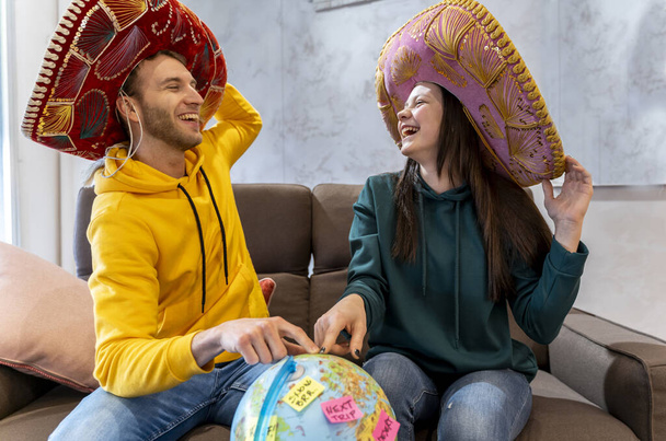 young couple is planning the next trip by choosing the destination on the globe map. concept of vacation in the world - Valokuva, kuva