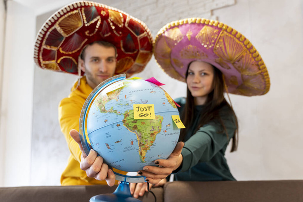 young couple is planning the next trip by choosing the destination on the globe map. concept of vacation in the world - Fotoğraf, Görsel