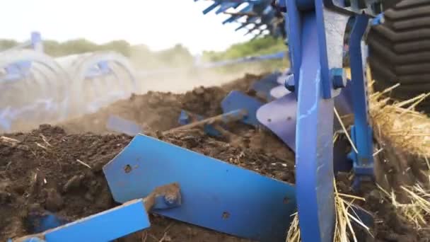 Agriculture industry team .Plow plows earth in field, steady shot, close up, slow motion - Footage, Video