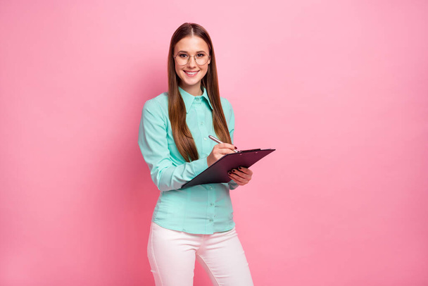 Portrait of charming pretty girl marketer hold clip board write to-do list check work tips wear good look teal clothes isolated over pastel color background - Φωτογραφία, εικόνα