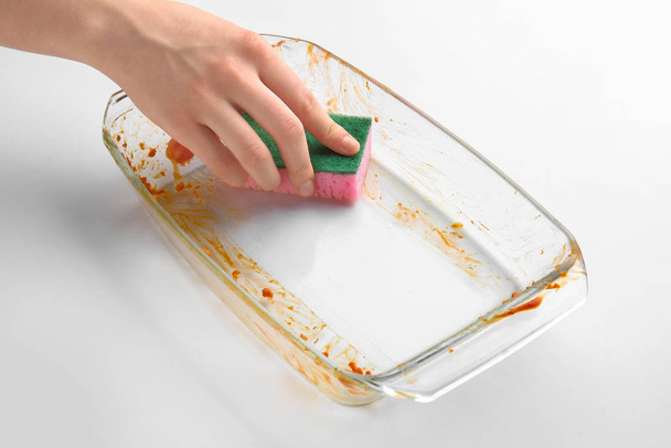 Жінка прибирає тарілку для випічки на білому тлі
 - Фото, зображення