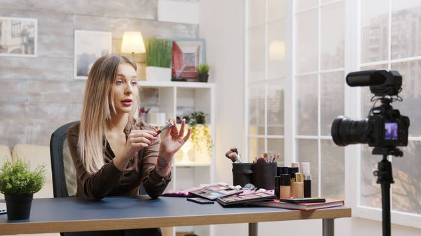 Atractiva influencer femenina grabando un video sobre maquillaje
 - Foto, imagen
