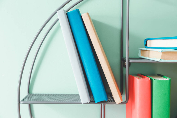 Estante con libros en la pared de color
 - Foto, imagen