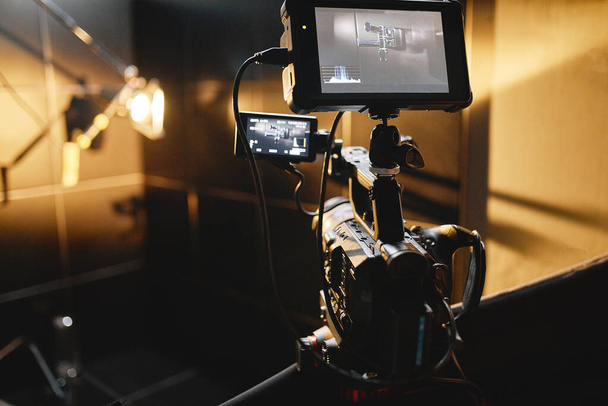 Videogyártás a színfalak mögött. A videótartalom-készítés kulisszái mögött egy profi operatőrcsapat reklámfilmeket forgató rendezővel. Videótartalom-készítés, videókészítő ipar. Kevés - Fotó, kép