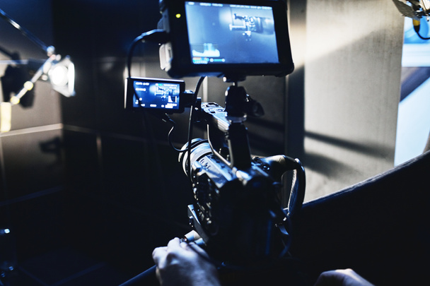 Video production backstage. Behind the scenes of creating video content, a professional team of cameramen with a director filming commercial ads. Video content creation, video creation industry. Low - Photo, Image
