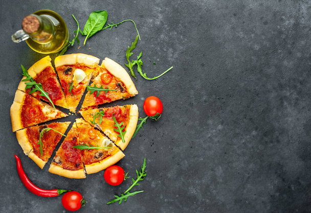 sabrosa pizza italiana con tomate, queso, huevos de codorniz salchicha sobre un fondo de piedra
 - Foto, imagen