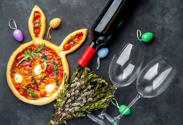 Celebração de conceitos Páscoa. Pizza festiva de coelho da Páscoa e uma garrafa de vinho
   - Foto, Imagem