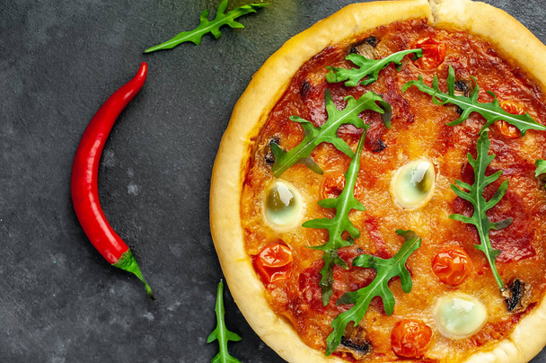 вкусная итальянская пицца с помидорами, сыром, колбасой из перепелиных яиц на каменном фоне
 - Фото, изображение
