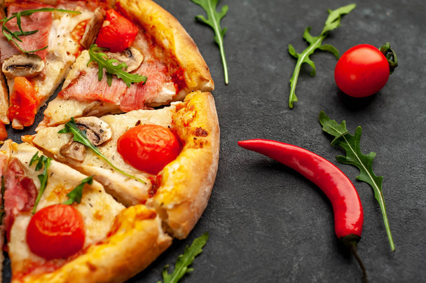 meat pizza with cheese, chicken, ham, mushrooms, tomatoes on a stone background  - Photo, Image