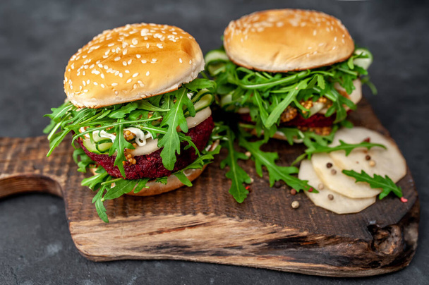 veggie hamburgers met bieten, kikkererwten, peer, arugula, komkommer op een snijplank op een stenen achtergrond - Foto, afbeelding