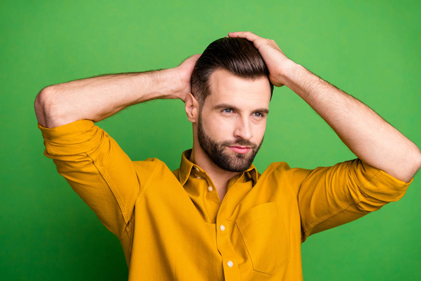 Close-up portrait of his he nice attractive well-groomed bearded guy touching hair modern coiffure haircut isolated over bright vivid shine vibrant green color background - Fotó, kép